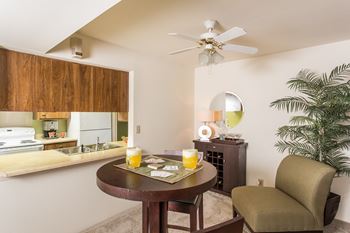 a dining area with a table and chair and a kitchen in the background  at Bay Pointe Apartments, Lafayette, IN, 47909